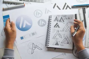 Brand refresh of a logo, with multiple sketches of logos on paper and in a notebook.